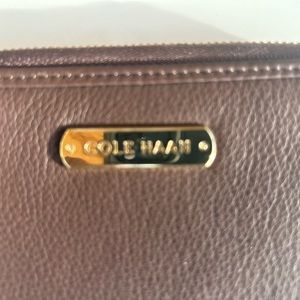 Brown “3x5 Cole Haan leather wallet with handy strap and gold zipper and seal.